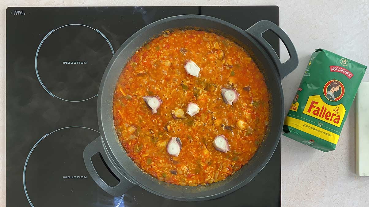 Receta arroz con pulpo paso 5 apagamos el fuego, colocamos unos trozos de pulpo por encima del arroz