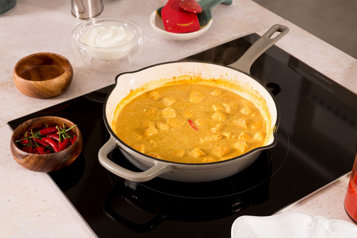 Receta pollo al curry paso 4 añadir el pollo que teníamos reservado a la sartén y junto con la leche de coco, el yogur griego, una guindilla picante o el pimentón picante y una pizca de sal y pimienta.