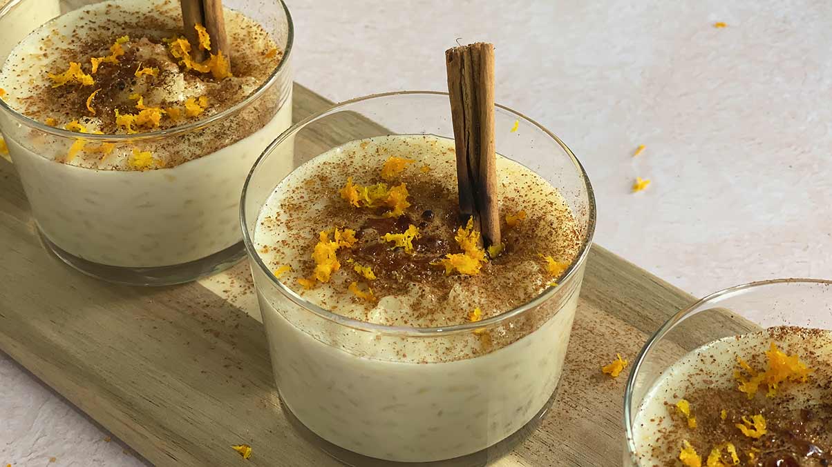 Arroz con leche cremoso - paso 3 servimos y ponemos una rama de canela, azúcar moreno la cual caramelizaremos con un soplete, canela en polvo y ralladura de naranja o limón