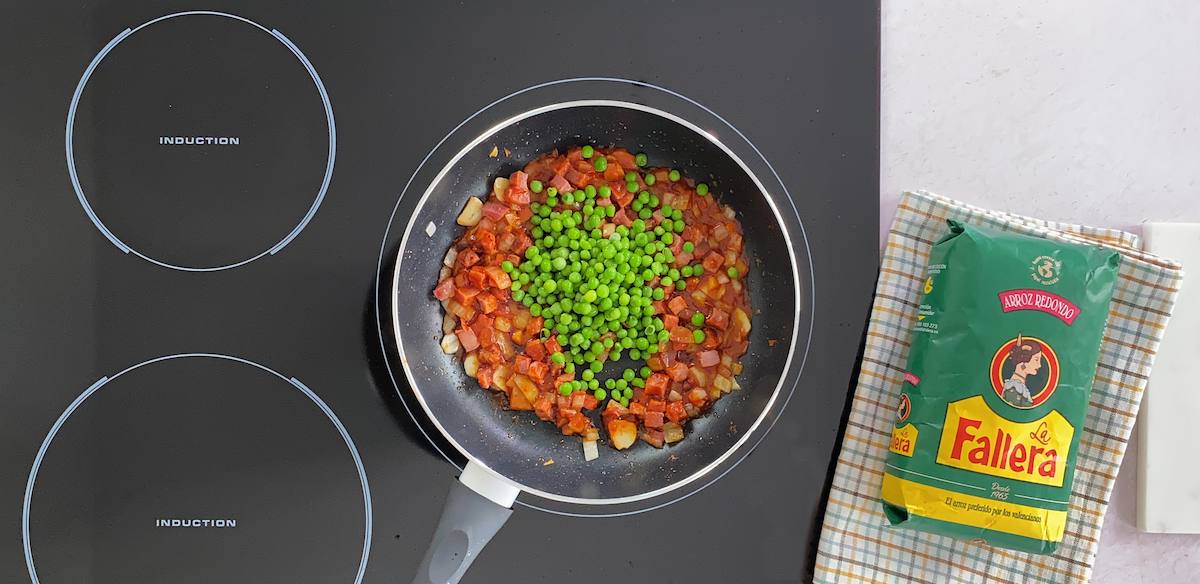 Paso a paso arroz con guisantes añadir guisantes y tomate