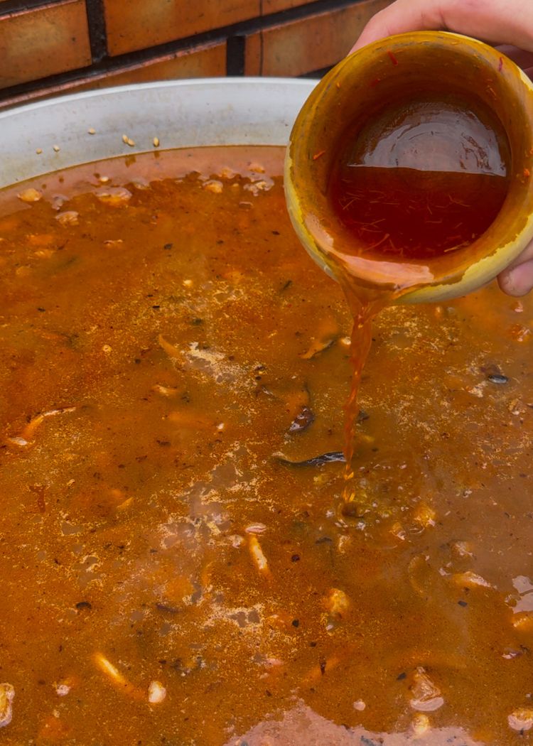 Añadir caldos a arroz con carne de cerdo
