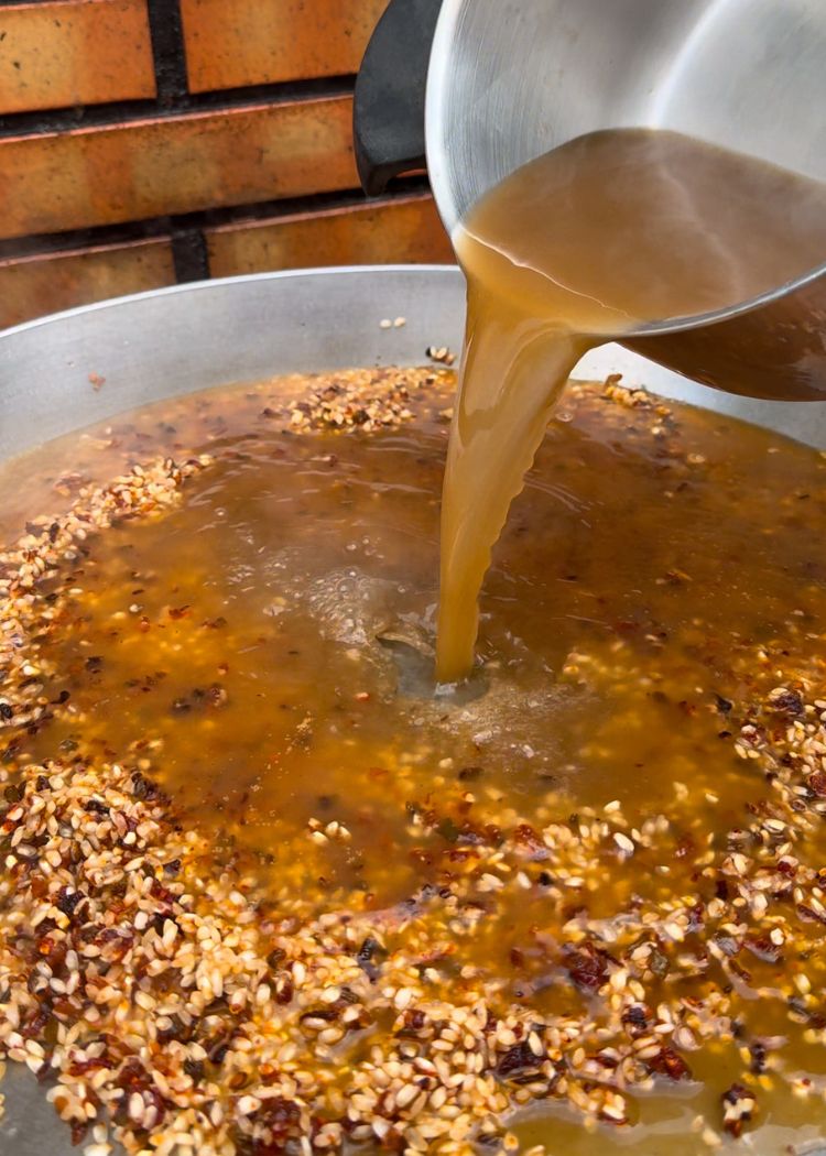 Verter caldo e infusión de azafrán a arroz con bonito