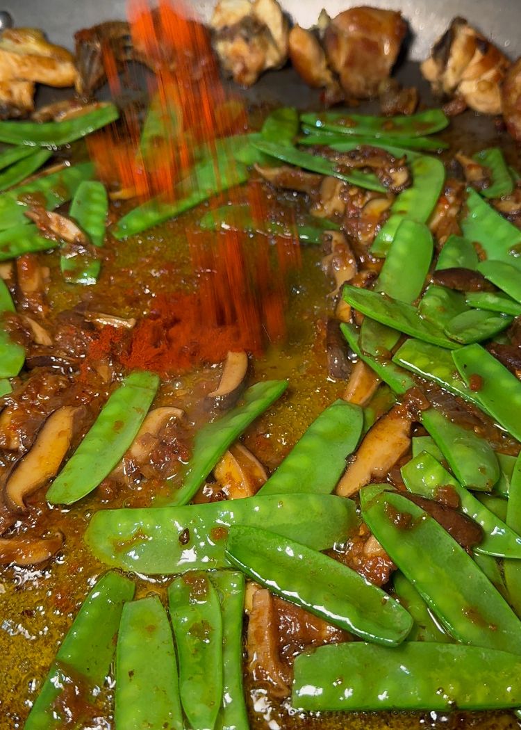 Añadir pimentón a paella de pollo y verduras