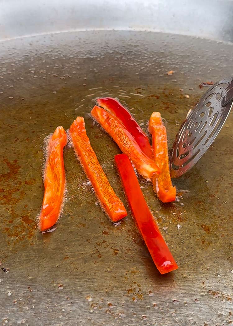 Sofreír pimientos para arroz con alitas de pollo