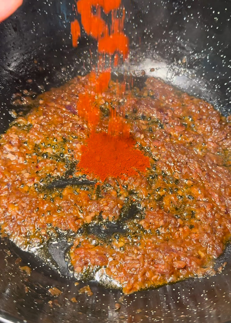 Añadir tomate y pimentón a arroz meloso con bogavante