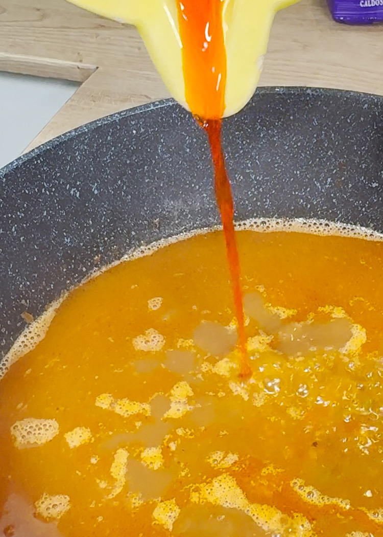 Verter caldo e infusión de azafrán a Arroz con mejillones