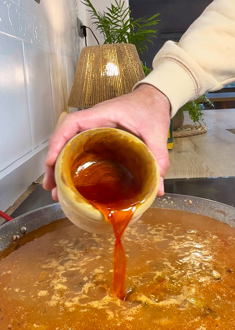 Verter caldo e infusión de azafrán a arroz con cosas