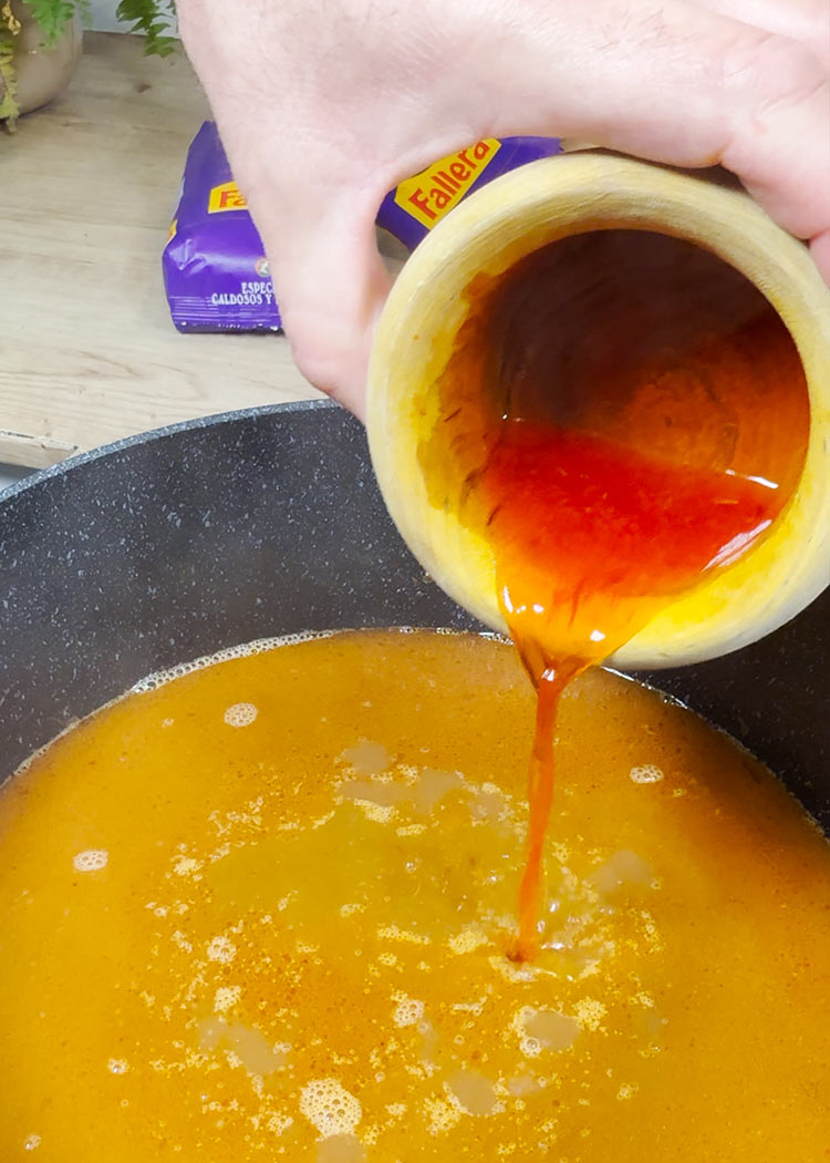 Verter caldo e infusión de azafrán a Arroz con chirlas