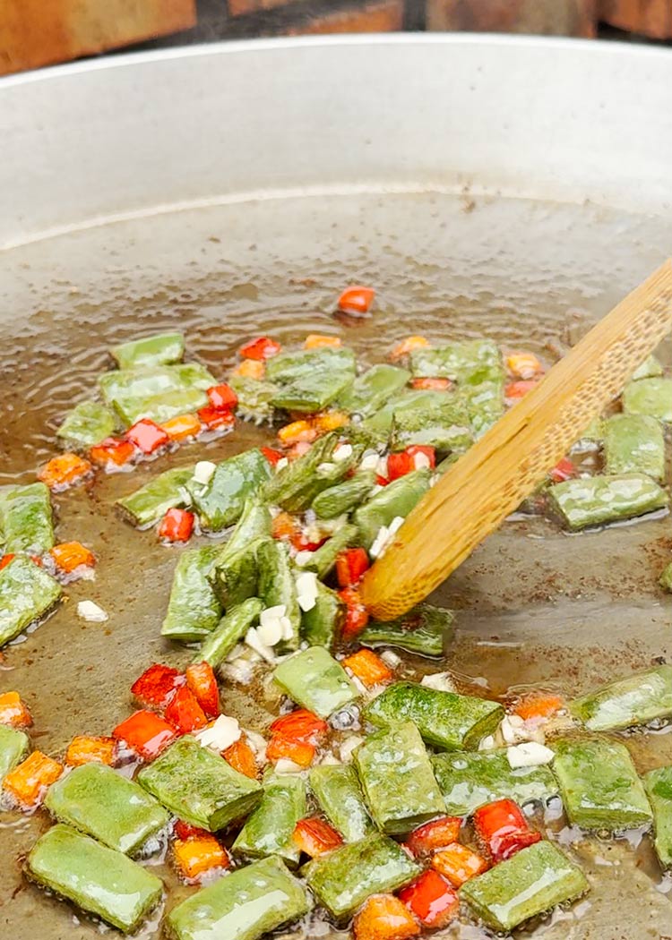 Añadir ajos picados a arroz con muslitos de pollo