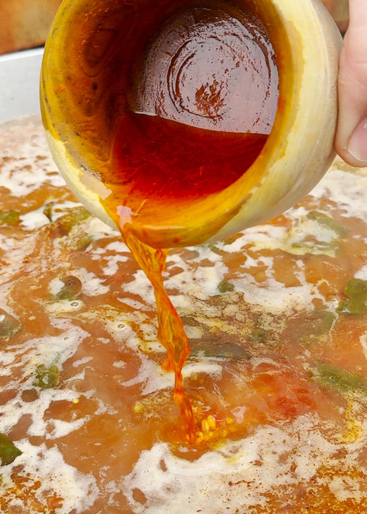 Verter caldo e infusión de azafrán a arroz con muslitos de pollo