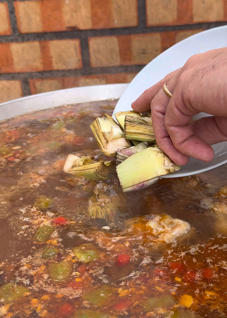 Incorporar carne y alcachofas a paella de carne