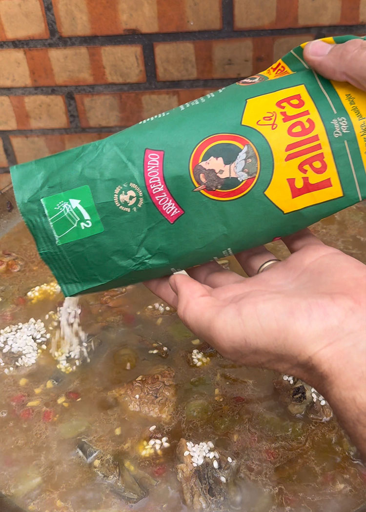 Echar arroz e infusión de azafrán a paella de carne