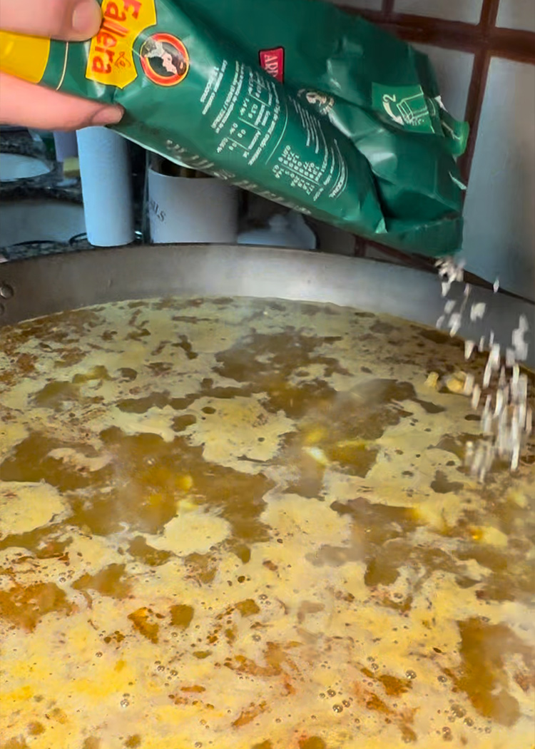 Incorporar arroz a paella de mariscos